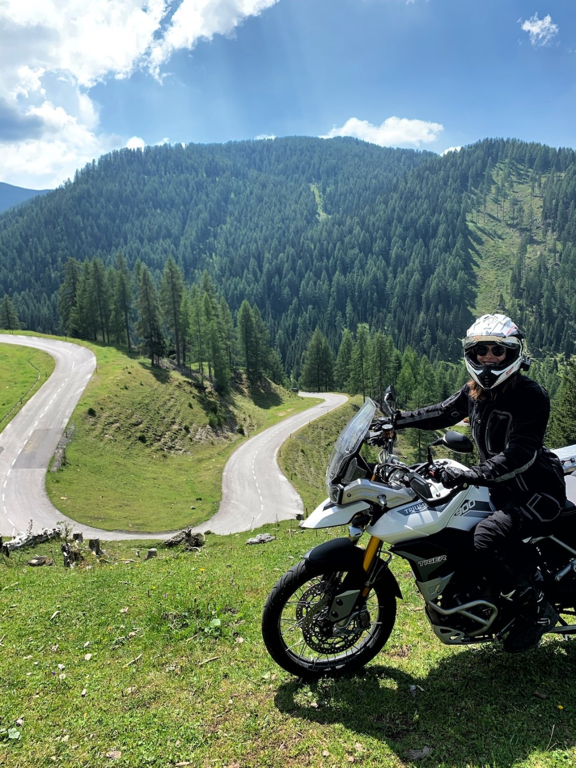 Woman sitting on Tiger 900 Rally Pro on Nockalmstrasse during roadtrip in Austria