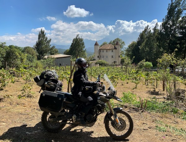 Woman on BMW F800GS motorbike in front on vineyards and CHÂTEAU DEFAY in Guatemala